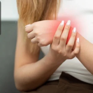 Woman holding her wrist in discomfort, symbolising the use of acupressure for pain relief.
