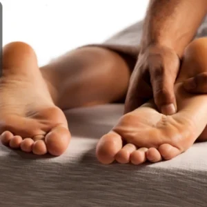 Therapist applying pressure to specific points on the sole of a foot, representing acupressure healing techniques.