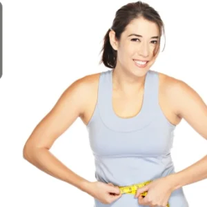 Smiling woman in fitness attire measuring her waist with a tape, symbolising weight loss and healthy living.