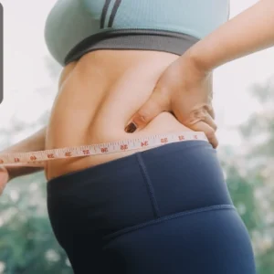 Person measuring their waist with a tape measure while wearing athletic clothing, representing fat loss and fitness, with the Thames College logo in the corner.