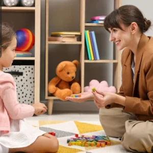 Child and therapist engaging in developmental activities with colourful blocks, symbolising autism support and learning.