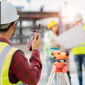 Construction site scene showing a surveyor using a walkie-talkie and measuring equipment while colleagues review blueprints, with the Thames College logo in the corner.