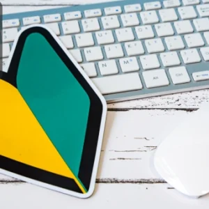 Computer keyboard and mouse on a desk with a beginner’s symbol card, representing entry-level digital design learning.