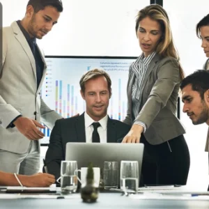 Business team collaborating around a laptop, symbolising global entrepreneurship and remote company formation in Estonia.