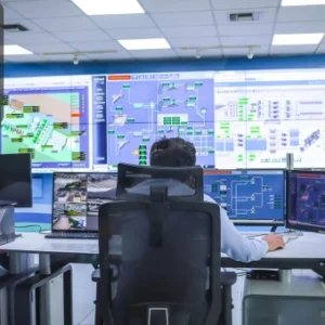 Engineer monitoring multiple digital control panels and system interfaces in a control room, symbolising embedded systems and advanced Arduino applications.