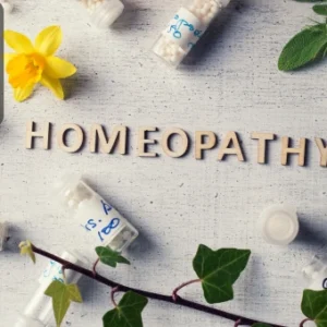 Bottles of homeopathic remedies with herbs and flowers representing alternative medicine and homeopathy.