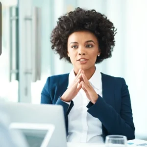 Confident businesswoman speaking during a meeting, symbolising clear and concise communication skills.