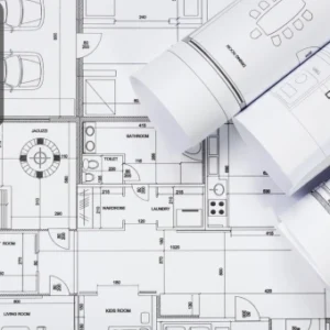 Rolled and unrolled architectural blueprints showing detailed floor and site plans.