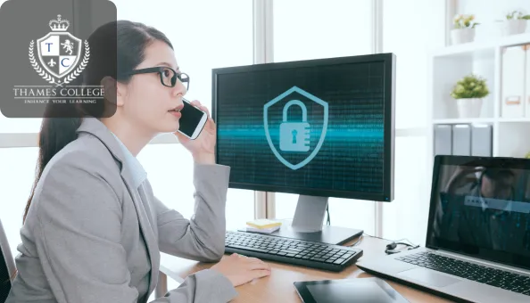 A professional in a suit talking on the phone while working on security management, with a digital lock symbol on the screen.
