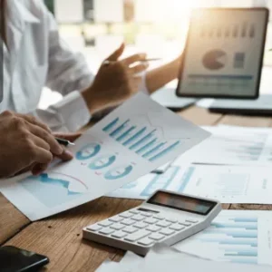 A team analysing charts, graphs, and reports on paper and digital devices, symbolising data analysis and GDPR compliance.
