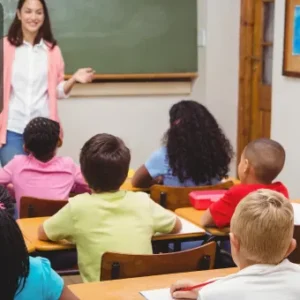 A teacher delivering a lesson to young children in a classroom, symbolising early years education and EYFS teaching principles.