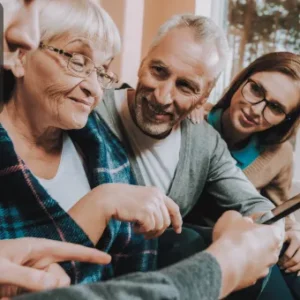 A family support worker interacting with an elderly woman and her family, showcasing the importance of family law and support in caregiving.