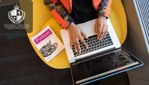 A person sits on a yellow chair, typing on a laptop with a Python programming book beside them. The laptop screen displays code. The Thames College logo is shown in the top left corner.