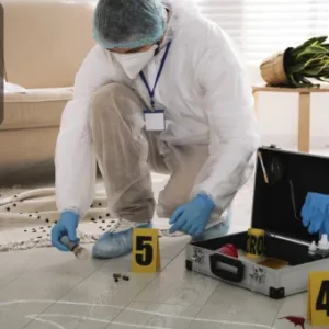 A forensic investigator in protective gear working at a crime scene, documenting evidence with numbered markers.