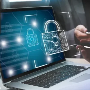 A laptop displaying digital padlock icons on the screen, symbolising cyber security, with people working in the background.