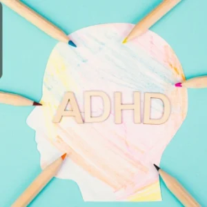 Silhouette of a human head filled with colourful patterns and the word “ADHD” in the centre, surrounded by pencils.