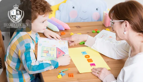 A therapist engaging a young child in an art therapy session using drawings and magnetic letters to support emotional expression and development.