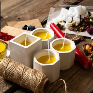 A creative candle-making setup featuring handmade candles, wax, dried flowers, essential oils, and twine on a rustic wooden table, with the Thames College logo in the top-left corner.