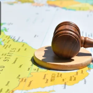 A wooden gavel resting on a map of North America, symbolising the concept of international legal governance.