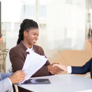 Two professionally dressed women are shaking hands across a table, with a man holding legal documents seated beside them; Thames College logo appears in the top-left corner.