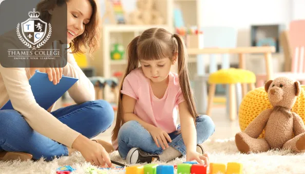 Adult female therapist engaging in play therapy with a young girl using colourful blocks on a soft carpet, surrounded by toys in a warm, child-friendly room.