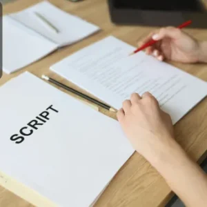 A person holding a red pencil reviews a printed script at a wooden desk with pages labelled “SCRIPT”; Thames College logo is displayed in the top-left corner.