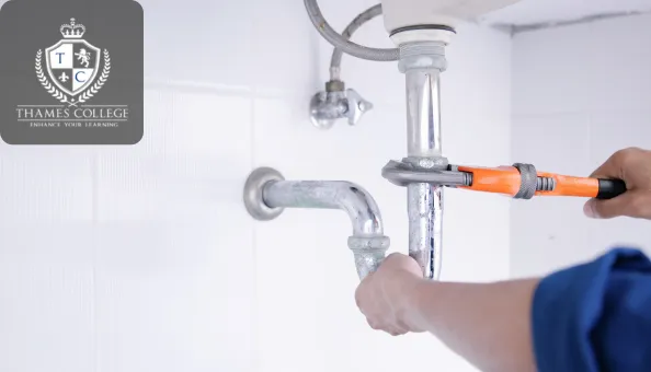 A person using a wrench to tighten a pipe under a sink, demonstrating hands-on plumbing work in a professional setting.