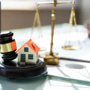 A gavel, a model house, and scales of justice, representing the intersection of property law and housing management in estate agency.