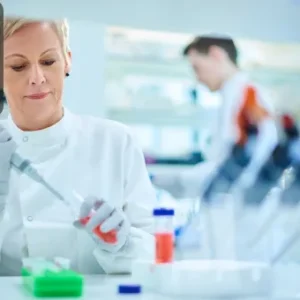 Pharmacologist in a laboratory conducting research with pipette and chemical samples.
