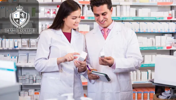 Two pharmacy technicians working together in a pharmacy, reviewing medication while using a digital device to assist with their tasks.